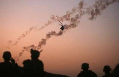 A U.S. helicopter releases flares while U.S. Marines take positions ...